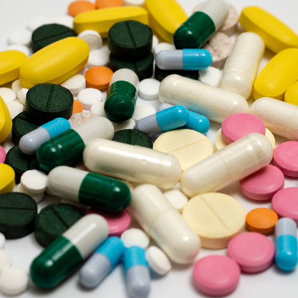 Pile of drugs in capsules and pills of different colors on a white background - Photo, Image