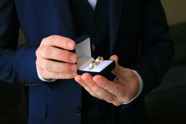 anillos de boda en cajas en las manos del novio - Foto, Imagen