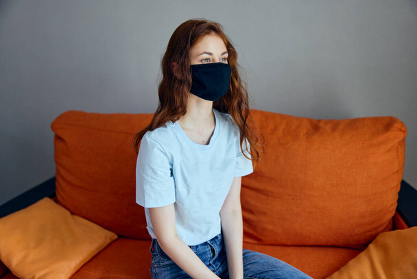 muotokuva nainen musta suojaava naamiot istuu sohvalla kotona Lifestyle - Valokuva, kuva