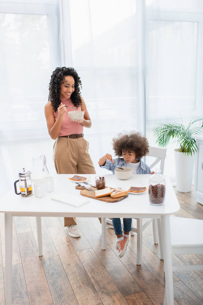 African american family eating breakfast near chocolate paste and bread at home  - 写真・画像
