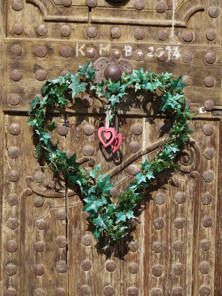 alte Holztüren mit Herz aus grünen Blättern - Foto, Bild