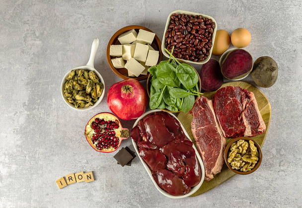 Foods high in Iron, including eggs, spinach, beans, tofu, liver, beef, beetroot, mussels, and dark chocolate.  - Photo, Image