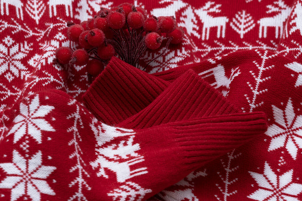 Un bouquet de baies d'hiver sur un pull rouge. Noel ou Nouvel An concept - Photo, image