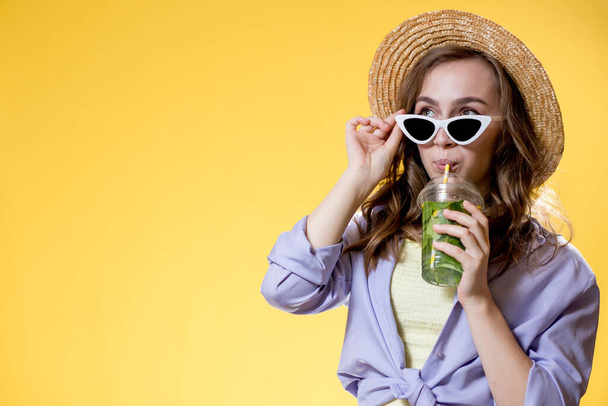 Summer refreshment. Cold beverage. Happy woman in sunglasses holding plastic glass of mojito. Non-alcoholic drink. Detox lemonade. - Valokuva, kuva