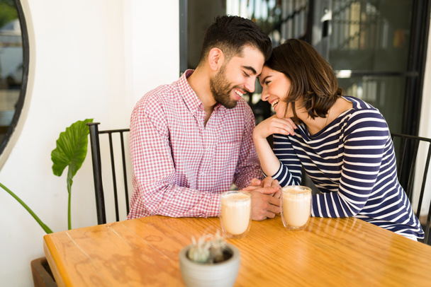 ¡Te amo! Amar a una joven pareja enamorada abrazándose y riéndose mientras tiene una cita romántica en una cafetería - Foto, imagen