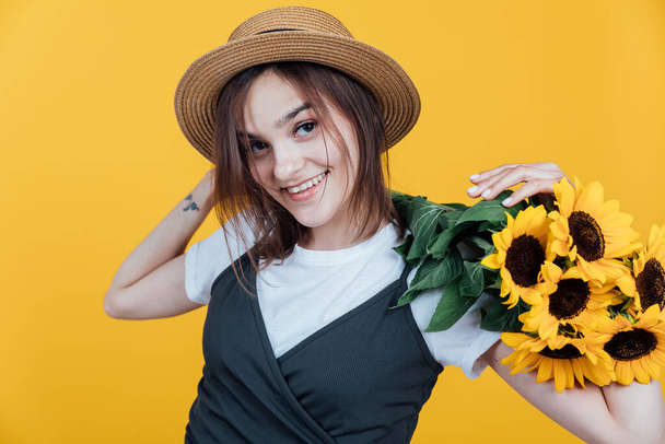 Porträt einer schönen Landfrau mit gelben Sonnenblumen - Foto, Bild