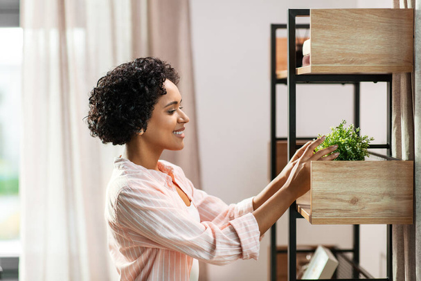 woman decorating home with flower or houseplant - Foto, immagini