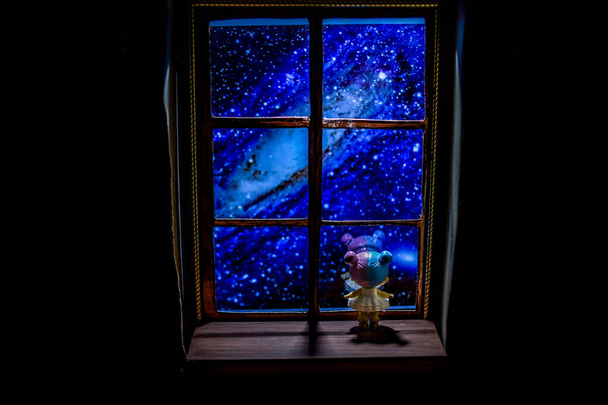 Kislány nézi a csillagokat az ablakon keresztül. - Fotó, kép