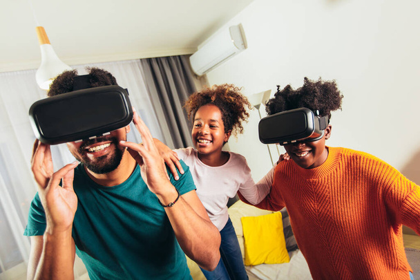 Сім'я грає у відеоігри з VR окулярами
. - Фото, зображення