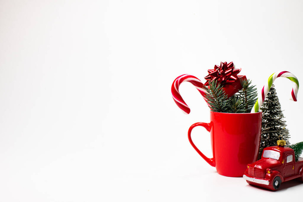 різдвяна композиція, червона чашка з цукерками палички цукерки, подарункова коробка, з ялинкою, червона вантажівка
 - Фото, зображення