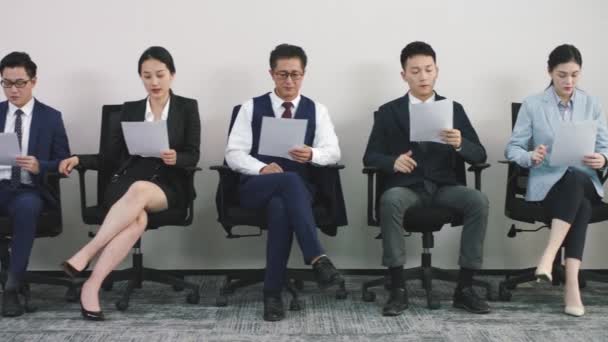 grupo asiático corporativo executivos trabalho candidatos sentado no alinhado até cadeiras esperando para entrevista - Filmagem, Vídeo