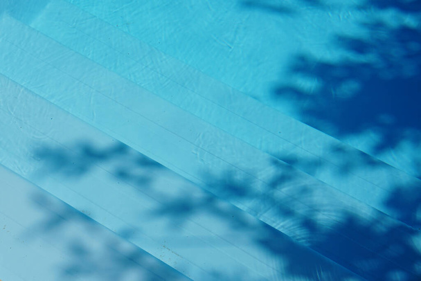 Μπλε νερό υφή φόντο το μεσημέρι φως του ήλιου με αφηρημένες σκιές - Φωτογραφία, εικόνα
