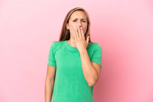 Young English woman isolated on pink background yawning and covering wide open mouth with hand - Foto, immagini