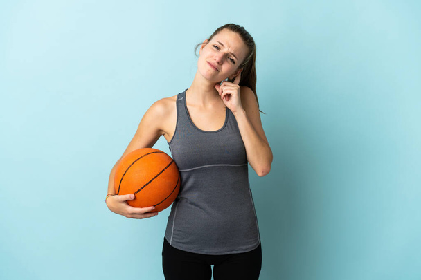 Mujer joven jugando baloncesto aislado sobre fondo azul teniendo dudas - Foto, Imagen