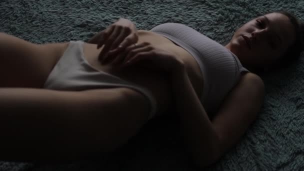 Uwodzicielska kobieta dotykająca ciała w domu - Materiał filmowy, wideo
