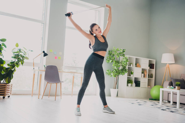 Full length body size view of attractive cheery sportive girl doing physical sports stretching muscles at light home studio indoors - Zdjęcie, obraz