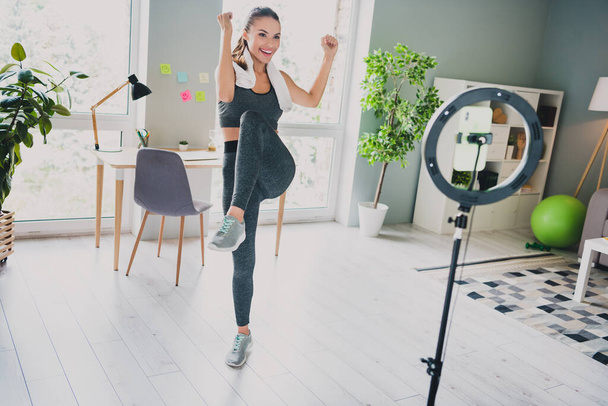 Фото симпатичної сильної леді носити спортивне вбрання посміхаючись відео навчання в приміщенні домашнього будинку
 - Фото, зображення