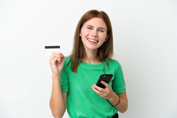 Fiatal angol nő elszigetelt fehér háttér vásárlás a mobil egy hitelkártya - Fotó, kép