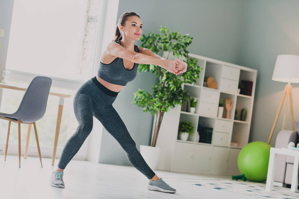 Photo of sweet confident young lady wear sport outfit smiling stretching practicing aerobics indoors home house - Φωτογραφία, εικόνα