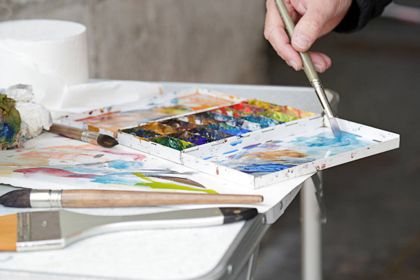 A painter using paint utensils (oil paint, artist brush) - Photo, Image