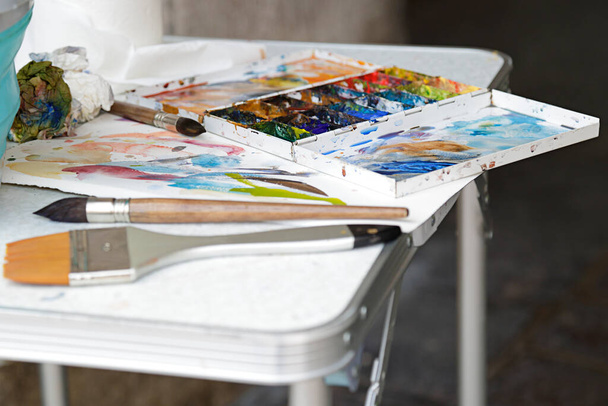 Umělecká paleta s olejovými barvami a štětcem na stole - Fotografie, Obrázek