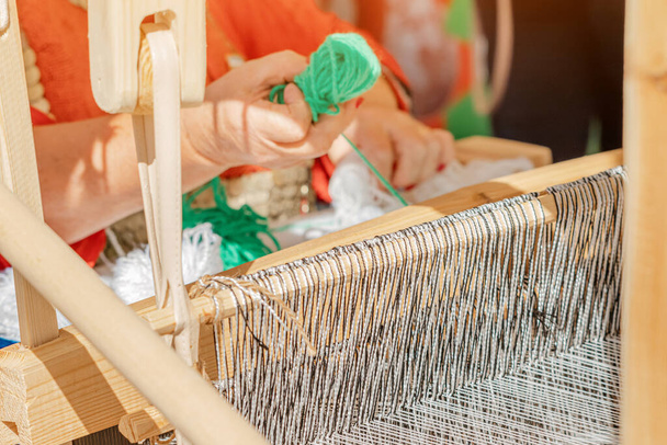 木製のレトロな職人スピナーマシンで綿糸を回転させます。文化と伝統の概念 - 写真・画像