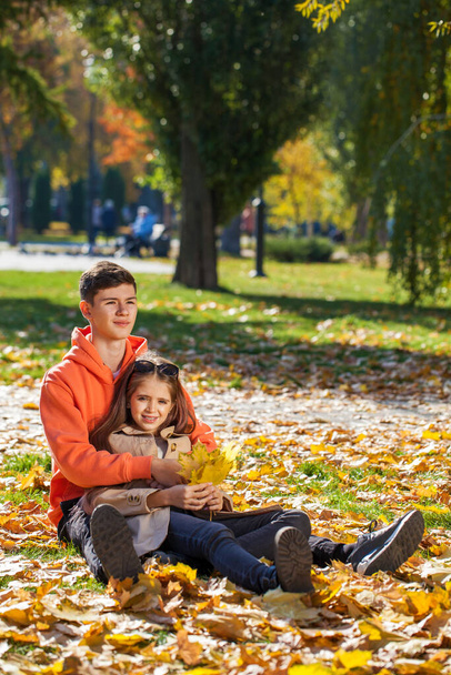 Happy teenager brother and sister in the autumn park - Valokuva, kuva