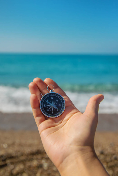 Compass in hands against the background of the sea. Selective focus. Travel. - Foto, Imagen