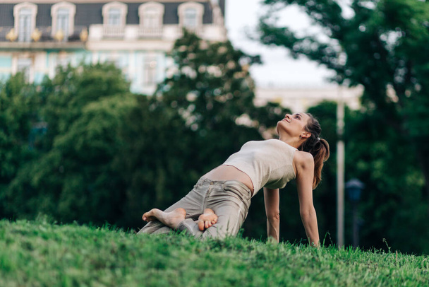 pose de loto, hermosa chica haciendo yoga posa en la puesta de sol en el parque, equilibrio, fitness, estiramiento y relajación - Foto, Imagen