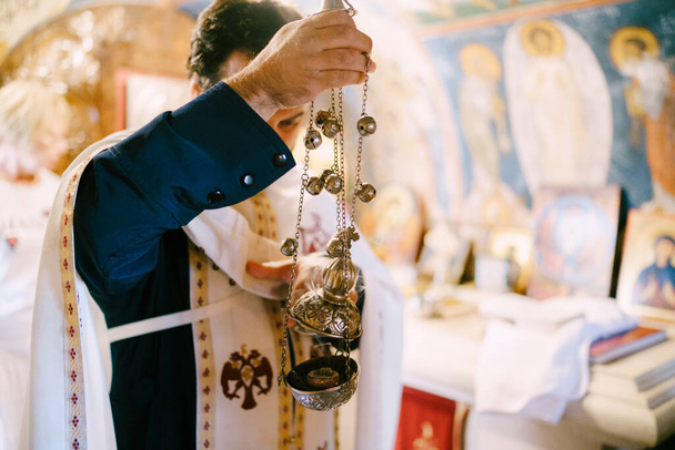 Prêtre avec un encensoir se tient dans l'église. Gros plan - Photo, image