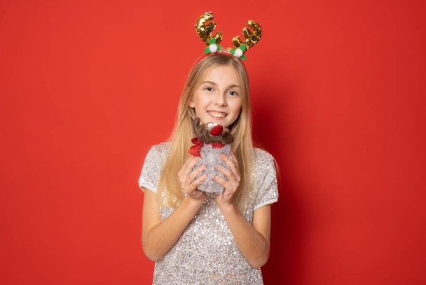 Menina bonita usando chapéu de Papai Noel para o Natal isolado no fundo vermelho. - Foto, Imagem