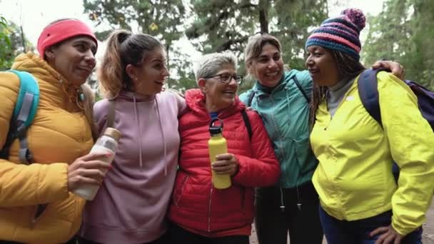 Farklı yaş ve etnik kökenlere sahip bir grup kadın sisli ormanda yürürken eğleniyor - Macera ve seyahat insanları kavramı  - Video, Çekim