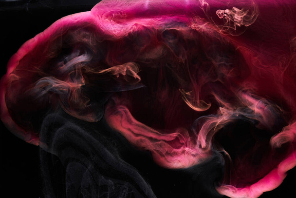 Pink smoke on black ink background, colorful fog, abstract swirling touch ocean sea, acrylic paint pigment underwater - Photo, image