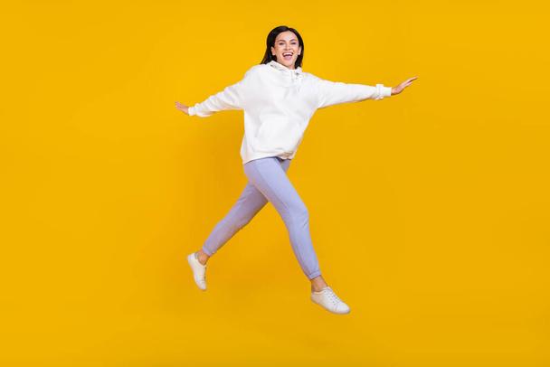 Full body photo of cheerful youth lady jump step stroll isolated over bright yellow color background - Foto, Imagen
