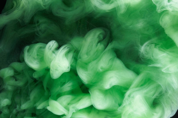 Green smoke on black ink background, colorful fog, abstract swirling emerald ocean sea, acrylic paint pigment underwater - Фото, зображення