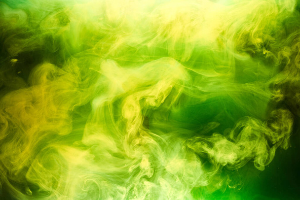 Green smoke on black ink background, colorful fog, abstract swirling emerald ocean sea, acrylic paint pigment underwater - Foto, imagen