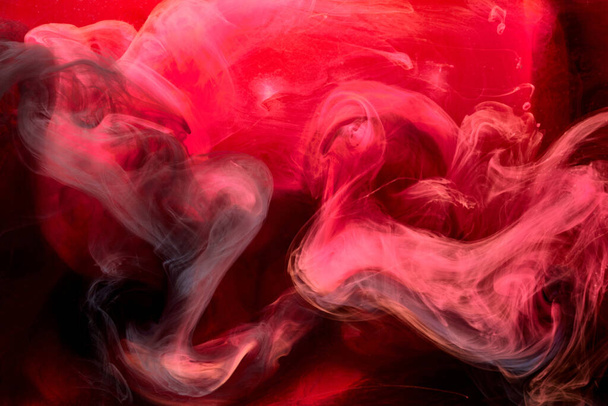 Red black pigment swirling ink abstract background, liquid smoke paint underwater - Фото, изображение