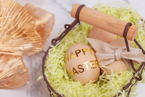 Close up wooden eggs in a decorative metal basket. Easter greeting card, banner, background. - Foto, Imagen