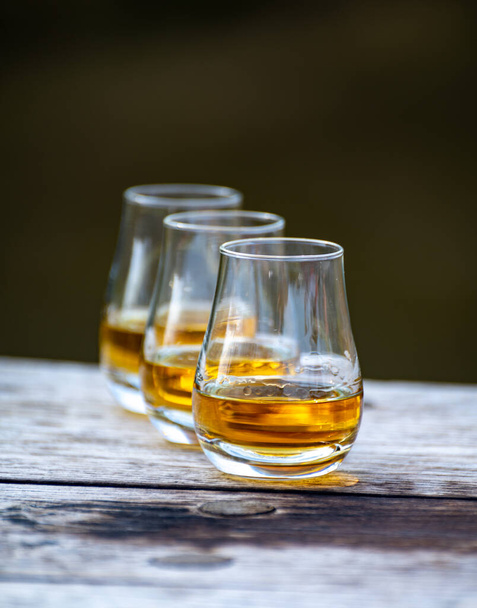 Degustationsgläser mit feinstem Scotch Whisky Starkgetränk auf altem Holztisch - Foto, Bild