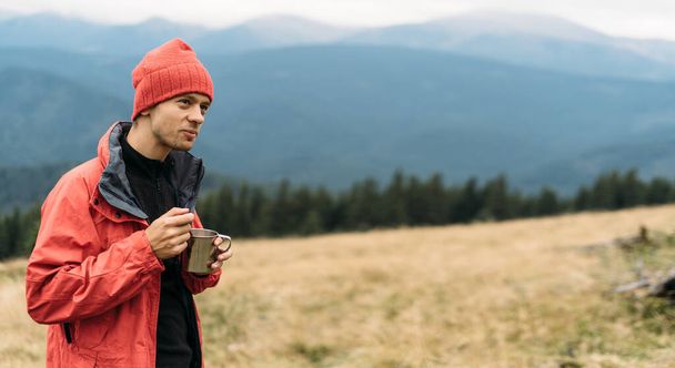 Portrait of caucasian tourist man eating fast food in the mountains, instant noodles for the traveler, delicious lunch in nature while relaxing. Baner. Copy space. - Foto, imagen