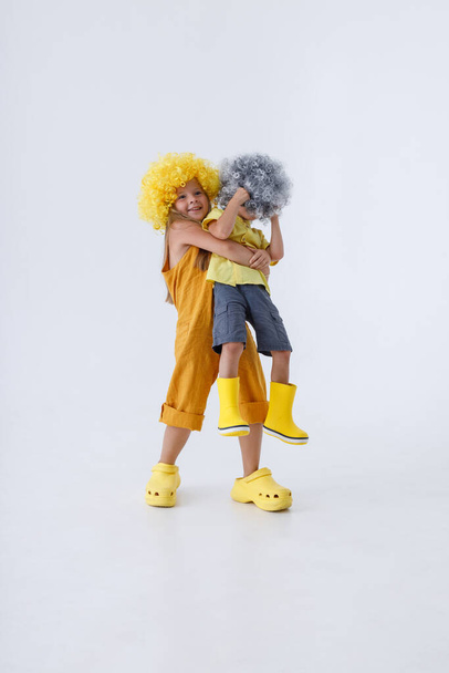Adorable girl holding her brother in studio - Foto, immagini