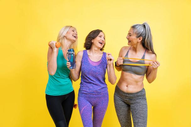 group of women with different body, age, and ethnicity making sport. Female models wearing sport outfits having fun at the gym. Concept about body positivity, self acceptance and lifestyle - Foto, Imagem