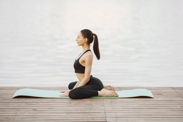 Donna che pratica yoga avanzato in riva al mare - Foto, immagini