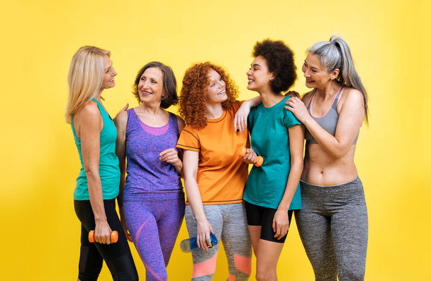 Group of women with different body, age, and ethnicity making sport. Female models wearing sport outfits having fun at the gym. Concept about body positivity, self acceptance and lifestyle - Valokuva, kuva