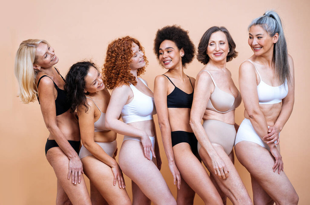 Beauty image of a group of women with different age, skin and body posing in studio for a body positive photoshooting. Mixed female models in lingerie on colored backgrounds - 写真・画像