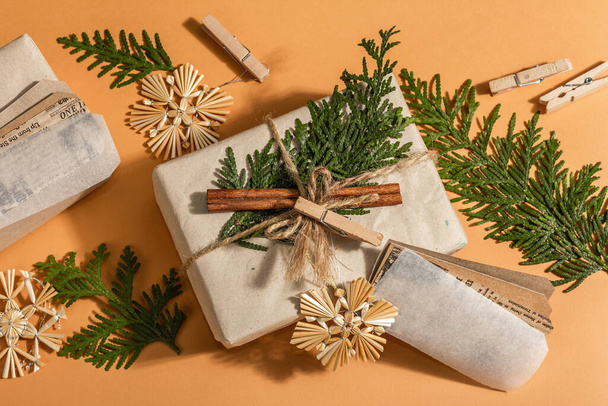 Zero waste gift concept. Christmas or New Year eco-friendly packaging. Festive boxes in craft paper with different organic decorations. Trendy hard light, dark shadow, top view, flat lay - Valokuva, kuva
