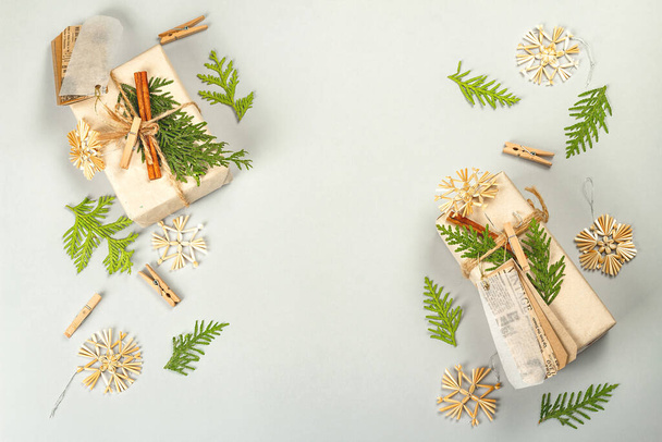 Concept de cadeau zéro déchet. Emballage écologique de Noël ou du Nouvel An. Boîtes festives en papier artisanal avec différentes décorations organiques. Fond gris clair, plan plat, vue sur le dessus - Photo, image