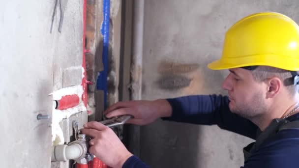Professionelle Klempnerarbeiten. Kaukasischer Arbeiter überprüft Wasserventile. - Filmmaterial, Video