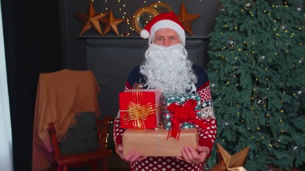 Senior grootvader parodieën Santa Claus presenteren kerstcadeau doos, feestdagen viering thuis - Video