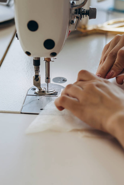 Egy kreatív ember ruhákat készít a varróasztalon. Ezek egy mechanikus berendezés a kézműves. - Fotó, kép